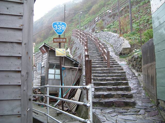 竜飛岬・民家の脇を階段国道が通るの写真の写真